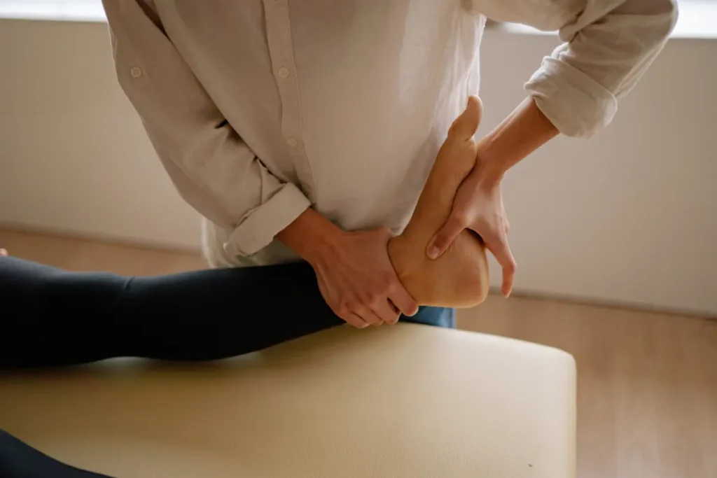 A physiotherapist performing manual mobilization on a patient's sprained ankle in Indore as a part of Ankle Sprain Physiotherapy in Indore.