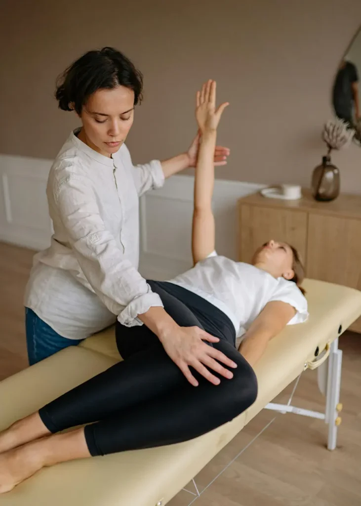 An expert physiotherapist in Indore assisting a patient with a specialized stretch to improve joint mobility at a physiotherapy clinic.